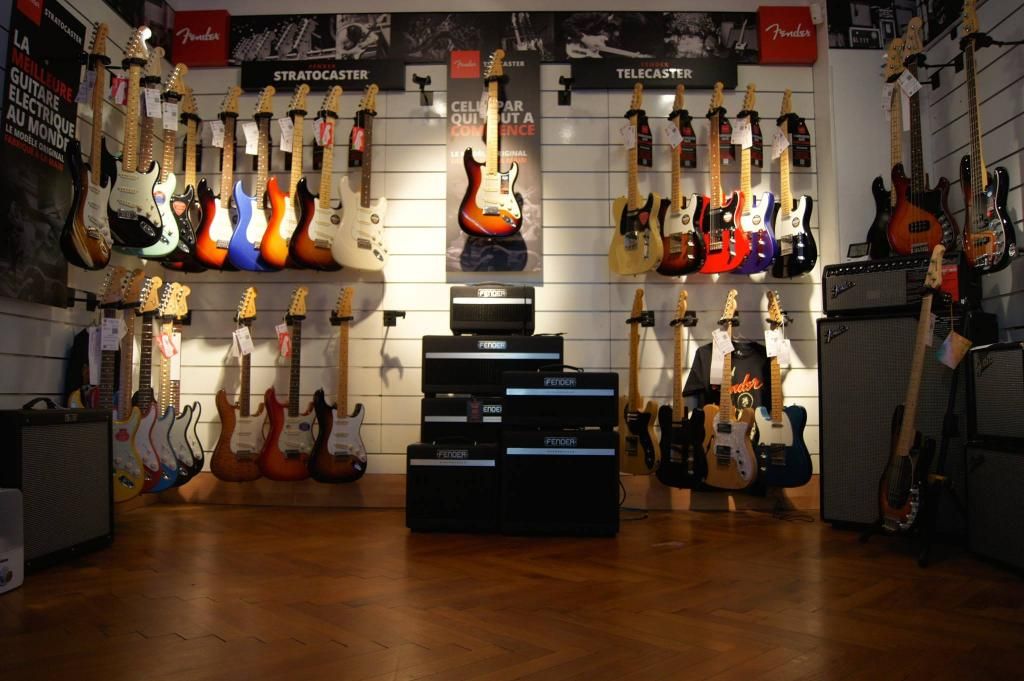 Mur de guitares électriques alignées dans un magasin